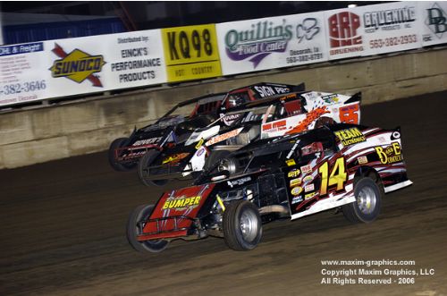 Jon Tesch (14) leads second-place chaser Al Hejna (outside) as they work around Alan Mondus (55). (Mike Roth/Maxim Graphics) 