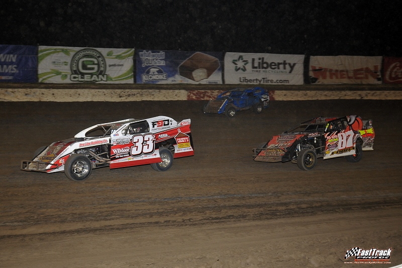 Zack VanderBeek (33z) leads Darron Fuqua (87) and a damaged Ryan Gustin (top) in the main event during the 3rd Annual Silver Dollar Nationals at the I-80 Speedway in Greenwood, Neb.